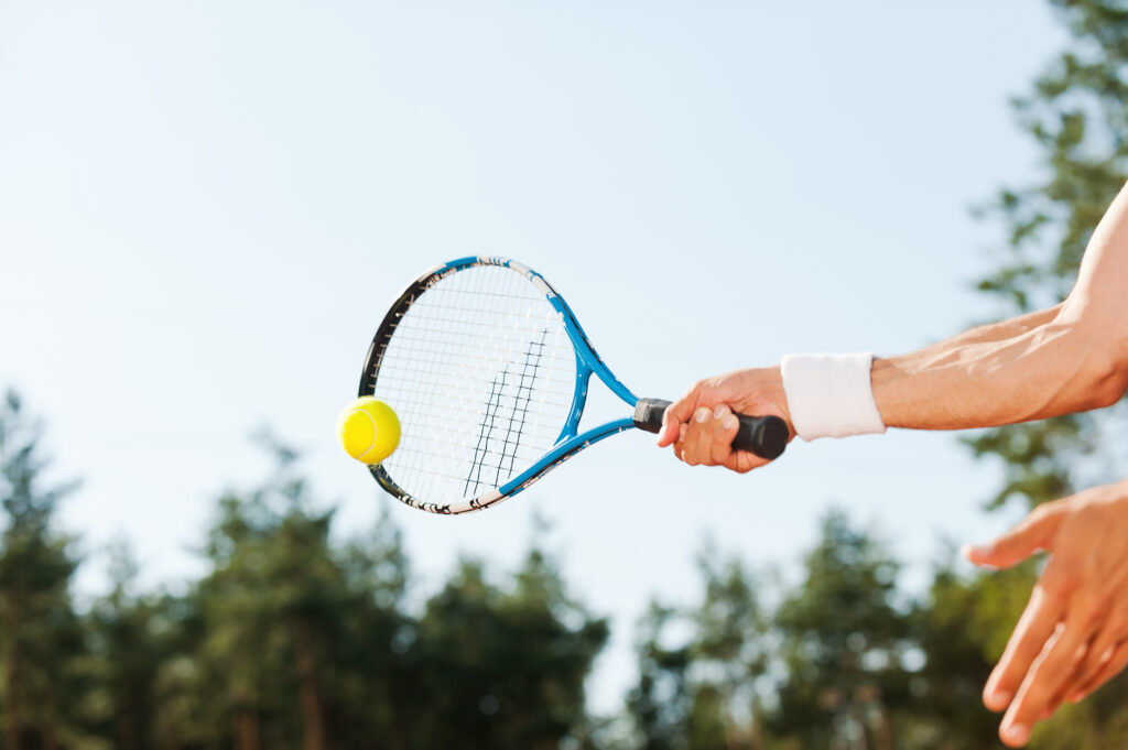 joueur tennis avec une raquette après un soin du poignet chez jb hand and wrist geneve